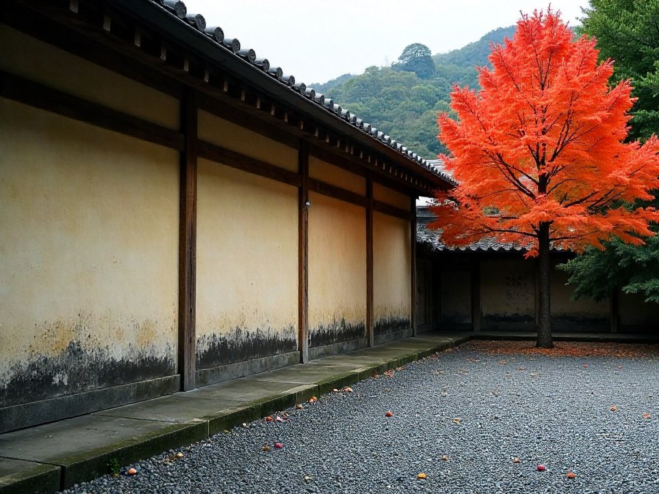 A raked gravel garden beside a Japanese temple wall